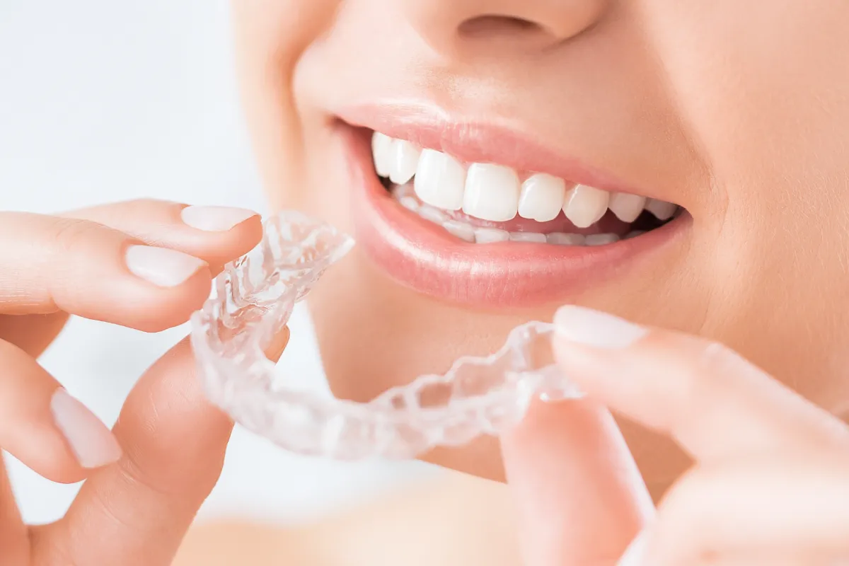 マウスピースを持って口元に近づけている女性