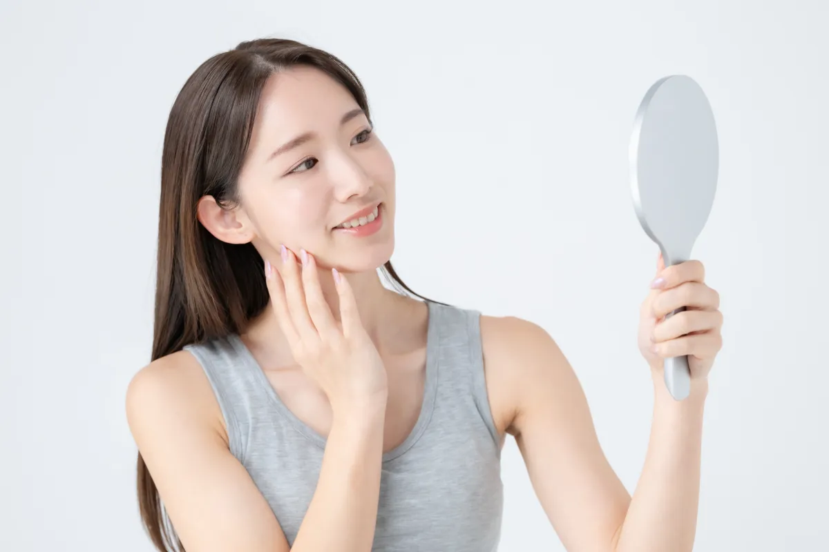 手鏡をもって自分の口元を確認している女性